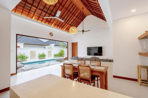 an open kitchen and dining room with a table and chairs at Villa Asri Nusa Dua in Nusa Dua