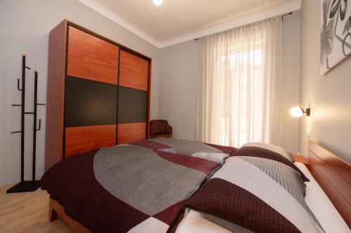 a bedroom with a bed with a large wooden headboard at Apartments Villa Salona in Opatija