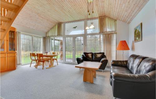 a living room with a leather couch and a table at Holiday Home M Eriksensvej I-933 in Bolilmark