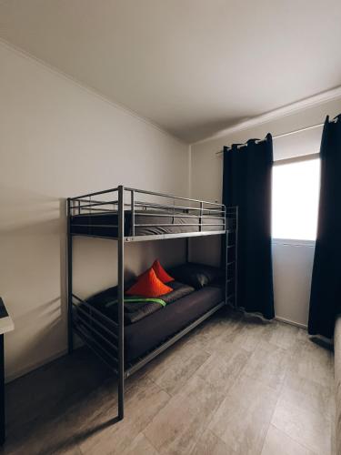 a bunk bed with two red pillows on it at Neuwertiges Apartment mit schnellem WLAN, Glasfaser, Kostenlose Privatparkplatz auch für Transporter geeignet R11 in Freiberg am Neckar
