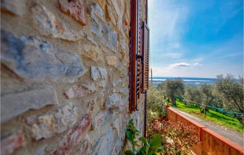 a window in a stone wall with a view of a field at Cozy Home In Massarosa With Kitchen in Massarosa