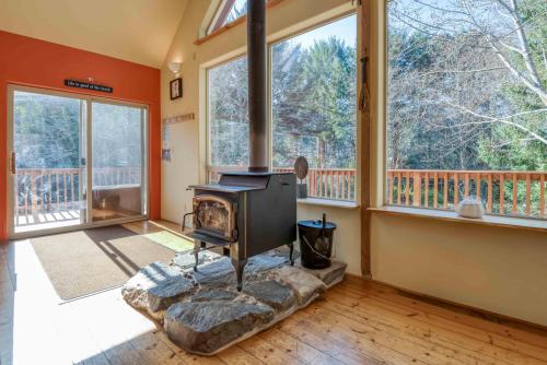 a living room with a fireplace and large windows at Dream Sea Chalet in Yachats