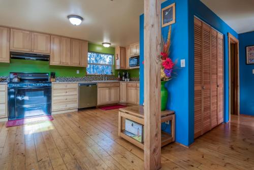a kitchen with blue and green walls and wooden cabinets at Dream Sea Chalet in Yachats