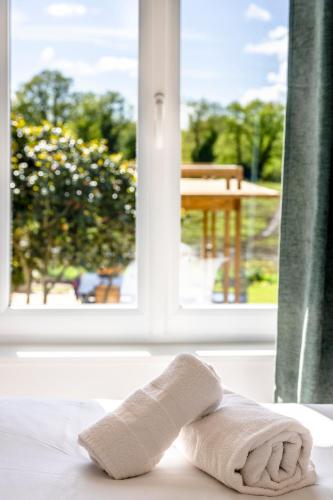une serviette assise sur une table devant une fenêtre dans l'établissement Lenesthan - Superbe gite tout confort et spa, à Saint-Jean-Brévelay