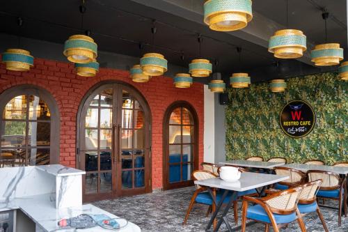 a restaurant with tables and chairs and a brick wall at Hotel W Grand - A Boutique Hotel in Haridwār