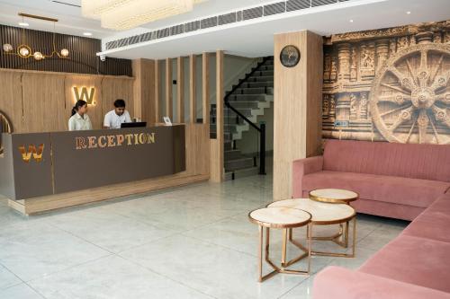 a lobby with a reception desk and two people at Hotel W Grand - A Boutique Hotel in Haridwār
