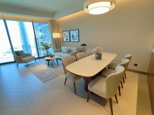 a dining room and living room with a table and chairs at 2BD Luxury Opera District Apt Downtown in Dubai