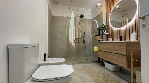 a bathroom with a toilet and a sink and a mirror at MALAGO Apartment in Siracusa