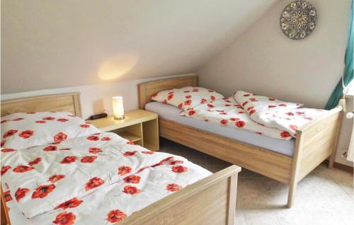 1 Schlafzimmer mit 2 Betten mit roten Blumen in der Unterkunft Nice Apartment In Osterbruch With Wifi in Osterbruch