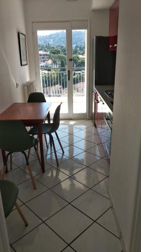 une salle à manger avec une table et des chaises et une cuisine dans l'établissement Beau 2 pièces centre de Cannes idéal congres et vacances, à Cannes