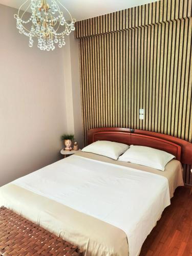 a bedroom with a large bed with a chandelier at 110 Sqm 2BR Edem beach luxury apartment in Athens
