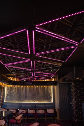 a stage with pink lights in a room with chairs at Hotel W Grand - A Boutique Hotel in Haridwār