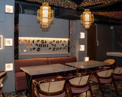 a restaurant with two tables and chairs and lights at Hotel W Grand - A Boutique Hotel in Haridwār