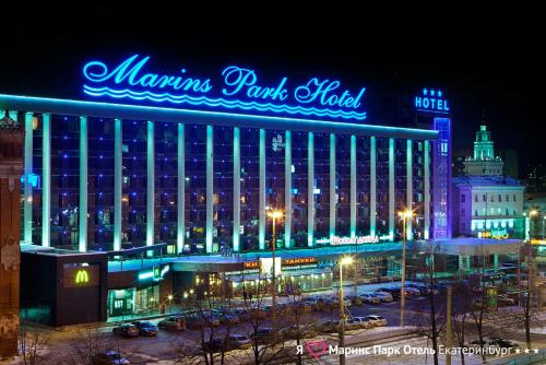 
a large building with a large clock on the side of it at Marins Park Hotel Yekaterinburg in Yekaterinburg
