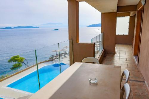 a balcony with a table and a view of the water at Cape Kanapitsa Hotel & Suites in Kanapitsa