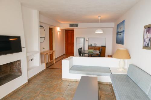 a living room with a couch and a fireplace at Cape Kanapitsa Hotel & Suites in Kanapitsa