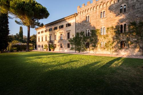 a large building with a large lawn in front of it at Borgo Pignano in Pignano