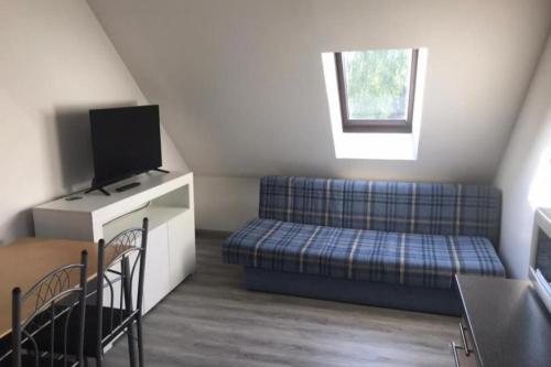 a small room with a couch and a tv at Fewo 71 Kleine 1 Raumwohnung in Roggow in Roggow