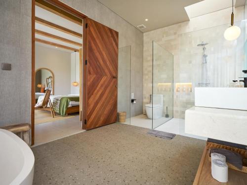 a bathroom with a shower and a toilet and a sink at Luna Ola Villa Berawa in Canggu