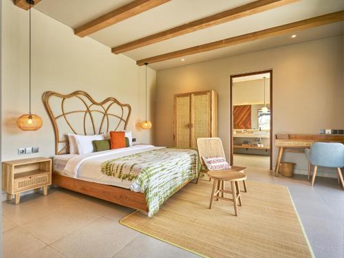 a bedroom with a bed and a desk and a chair at Luna Ola Villa Berawa in Canggu