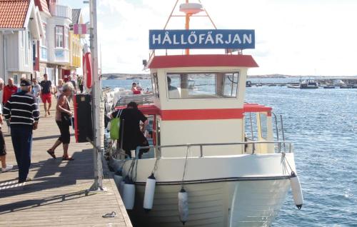 a boat docked at a dock with people walking on it at Stunning Apartment In Kungshamn in Kungshamn