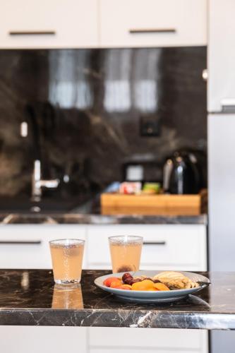 a plate of food on a counter with two glasses at Vardas Luxury Houses in Lefkada