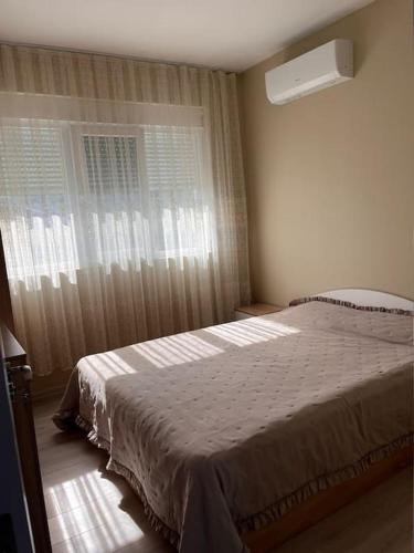 a bedroom with a large bed and a window at Вила in Asprovalta