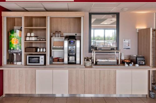 a kitchen with a counter with several appliances at Ace Hôtel Paris Sud Villabe in Villabé