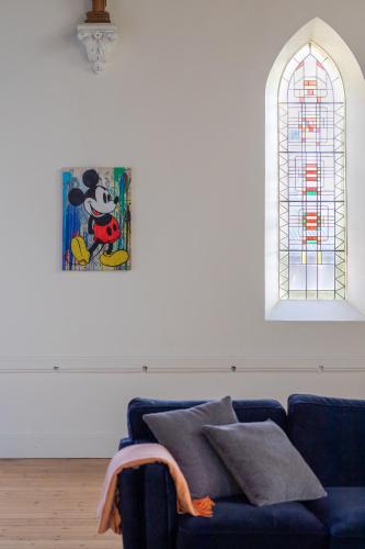 a living room with a blue couch and a stained glass window at The Church at Haven on High in Campbell Town