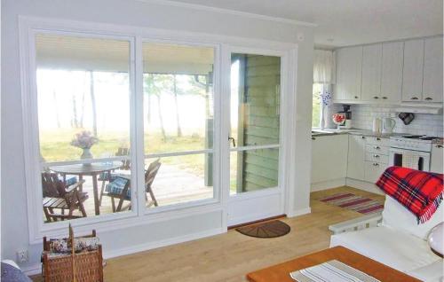 a living room with a large window and a table with chairs at Two-Bedroom Holiday Home In Hyltebruk in Löjenäs