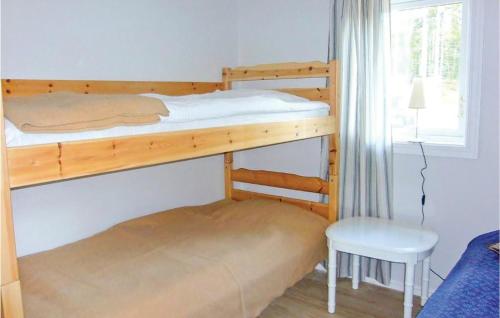 a bunk bed in a room with a chair and a desk at Two-Bedroom Holiday Home In Hyltebruk in Löjenäs