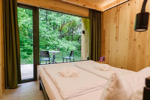 OposhnyaにあるOBRIY holiday villageのベッドと大きな窓のある寝室