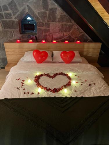 two hearts on a bed with lights on it at AYDER VANAK STONE SUİTES in Ayder Yaylasi