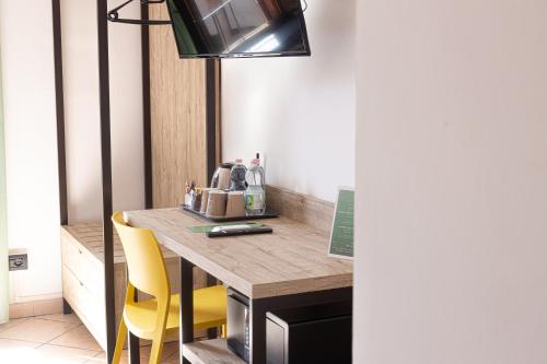 a kitchen with a table and yellow chairs at Hotel Tornielli 9 by LVG Hotel Collection in Novara