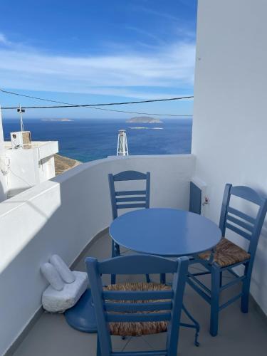 a blue table and chairs on a balcony with the ocean at Anafi Tholos House in Anafi