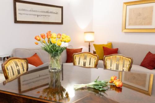 a vase of flowers on a table in a living room at Ca' Spadoni, centro storico, piano terra, ingresso indipendente, teatro, parcheggio, in Imola