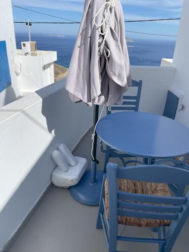 a table and chairs on a balcony with the ocean at Anafi Tholos House in Anafi
