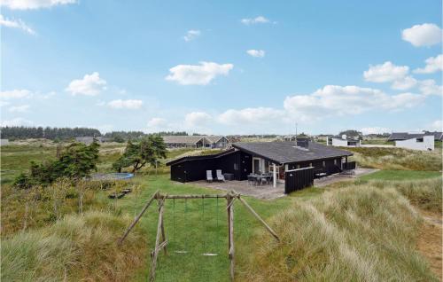 a black house in the middle of a field at Holiday Home Ringkobing Xliii in Klegod