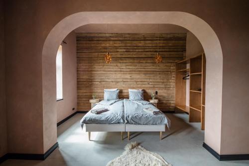 a bedroom with a bed and a wooden wall at Ilmaveere Butiikhotell ja Restoran in Obinitsa