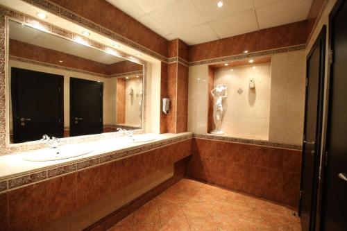 a bathroom with two sinks and a large mirror at Hotel & Restaurant The House in Sofia