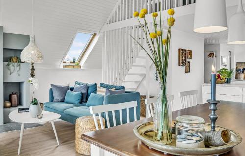 a living room with a blue couch and a table at Holiday Home Kræ Degns Vej Ringkøbing Iii in Klegod