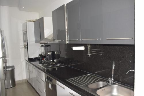 a kitchen with a black counter top and a sink at Magnifique appartement à Riad Garden in Marrakech