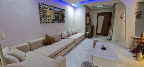 a living room with a white couch and a mirror at Magnifique appartement à Riad Garden in Marrakech