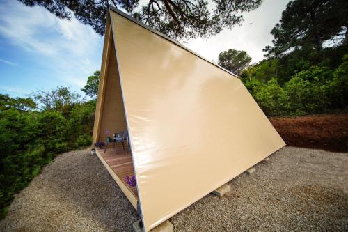 a large metal clad house with a wooden deck at Glamping Fonte Murata in Portoferraio