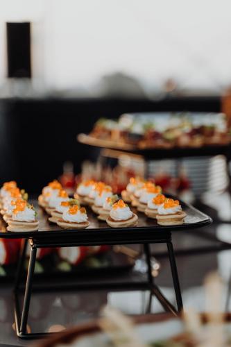 a tray of cupcakes with orange toppings on them at Union Plaza Hotel in Bucharest