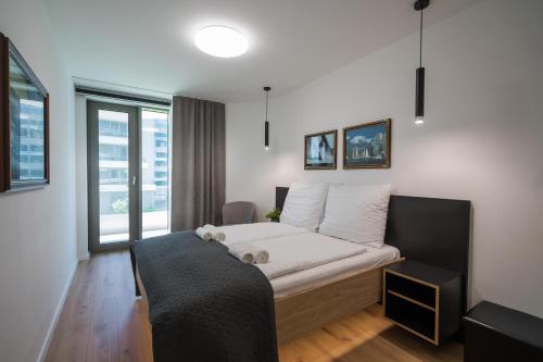 a bedroom with a bed and a large window at MyFlat Wave Yacht Apartment in Siófok