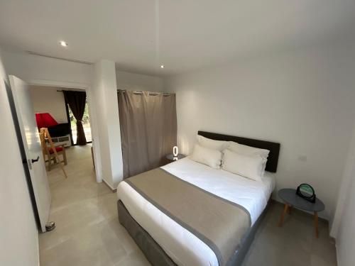 une chambre avec un lit blanc et une table dans l'établissement Casa Mya, à Porto-Vecchio
