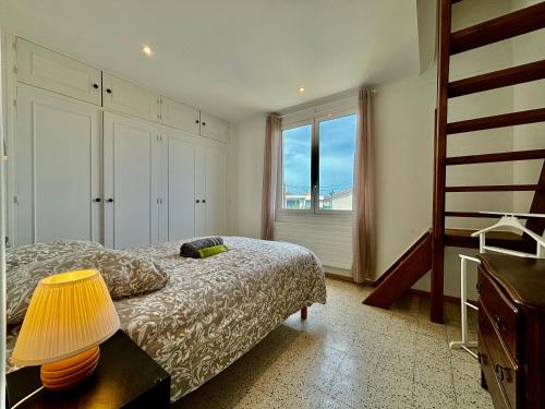 une chambre avec un lit avec une lampe et une fenêtre dans l'établissement Spacieux Appartement, Grande Terrasse et Parking Privé !, à Mandelieu-la-Napoule