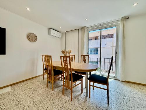 une salle à manger avec une table, des chaises et une horloge dans l'établissement Spacieux Appartement, Grande Terrasse et Parking Privé !, à Mandelieu-la-Napoule