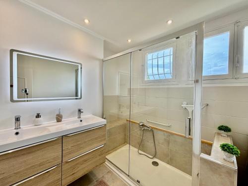 une salle de bain avec une douche, un lavabo et un miroir dans l'établissement Spacieux Appartement, Grande Terrasse et Parking Privé !, à Mandelieu-la-Napoule